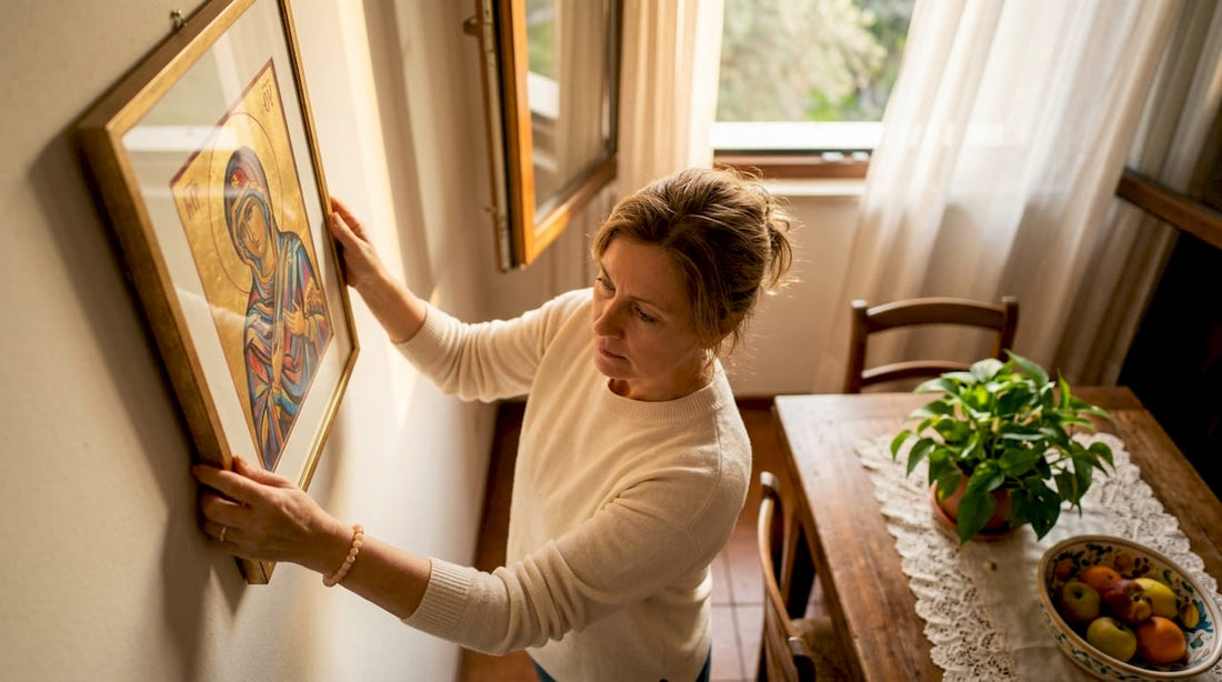 Woman hanging Christian artwork in living room