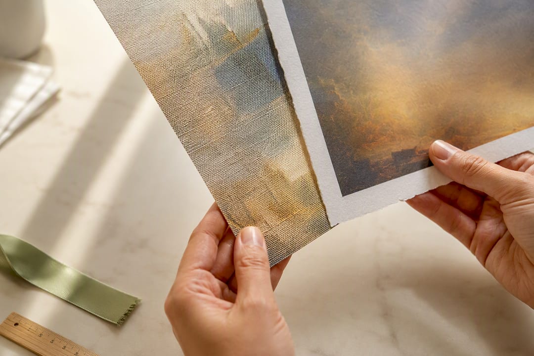 Hands comparing canvas and paper print textures
